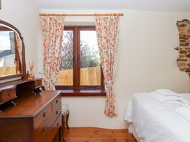A bedroom with a window and dresser at The Cottage in Sampford Courtenay