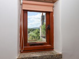 A window with a view of a chimney and mountains at The Cottage in Sampford Courtenay