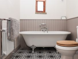 A bathroom with a bathtub and toilet at The Cottage in Sampford Courtenay