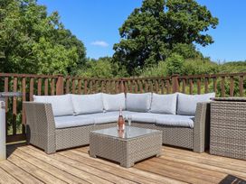 A deck with an outdoor sofa and coffee table at The Cottage in Sampford Courtenay
