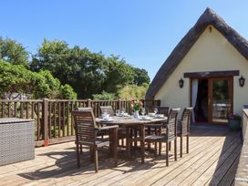 An outdoor patio with a dining table and chairs at The Cottage in Sampford Courtenay