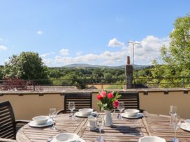 An outdoor dining table set with plates and glasses at The Cottage in Sampford Courtenay
