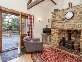 A living room with a fireplace and a chair at Miners Dry in Gulworthy, near Tavistock