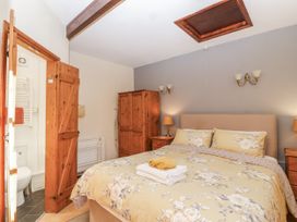 A bedroom with a bed and wardrobe at Miners Dry in Gulworthy, near Tavistock