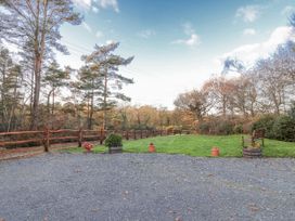 An outdoor area with trees, a bench, and gravel at Miners Dry, Gulworthy, near Tavistock