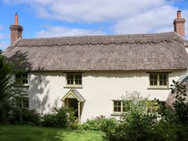 A cottage with a thatched roof and garden at Hope Cottage in Riddlecombe, near Winkleigh