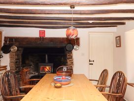 A kitchen with table and chairs near a fireplace at Hope Cottage in Riddlecombe, near Winkleigh