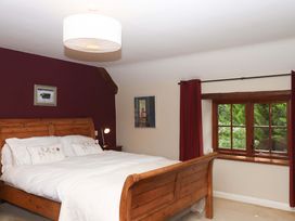 A bedroom with a wooden bed and window at Hope Cottage in Riddlecombe, near Winkleigh