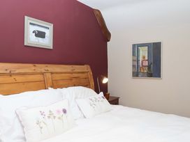 A bedroom with a wooden bed and framed pictures at Hope Cottage Riddlecombe, near Winkleigh
