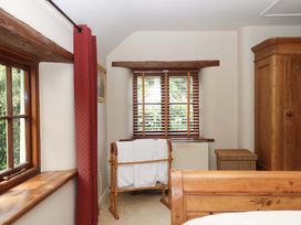 A bedroom with a window, wardrobe, and washing rack at Hope Cottage, Riddlecombe near Winkleigh