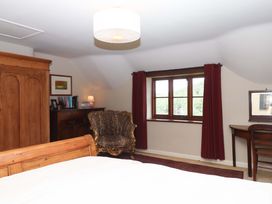 A bedroom with a bed and wardrobe at Hope Cottage in Riddlecombe near Winkleigh