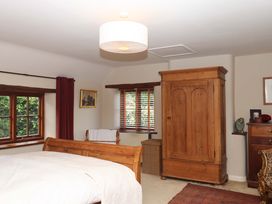 A bedroom with a bed and wardrobe at Hope Cottage in Riddlecombe, near Winkleigh