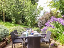 A garden with a dining table and chairs at Hope Cottage near Winkleigh