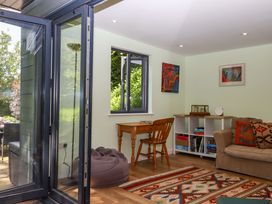 A snug with a table, chair, and bookshelf at Hope Cottage in Riddlecombe, near Winkleigh