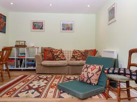 A living room with a sofa and bookshelf at Hope Cottage Riddlecombe near Winkleigh