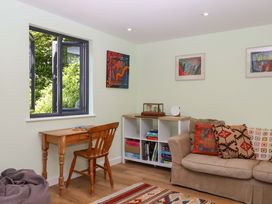 A living room with a table and chair at Hope Cottage in Riddlecombe, near Winkleigh