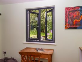 A window with an outdoor view and a table with books at Hope Cottage, Riddlecombe, near Winkleigh
