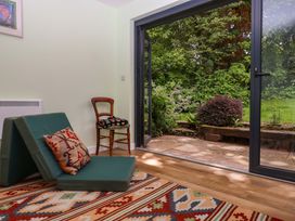 A snug with a folding chair and rug at Hope Cottage in Riddlecombe, near Winkleigh