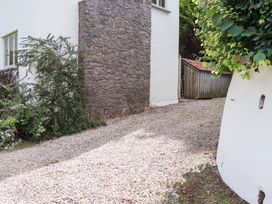A gravel driveway alongside a stone wall and a shed at Hope Cottage in Riddlecombe, near Winkleigh