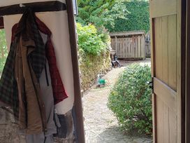 A garden pathway with coats on a hook at Hope Cottage, Riddlecombe, near Winkleigh