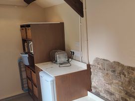 A kitchen area with a refrigerator, toaster, and microwave at Hope Cottage Riddlecombe near Winkleigh