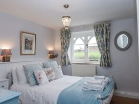 A bedroom with a bed and window at Chapel Cottage Welcombe