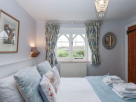 A bedroom with a bed and window at Chapel Cottage in Welcombe