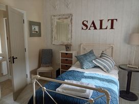 A bedroom with a bed and decorative items at Saltwind Granary in Clovelly
