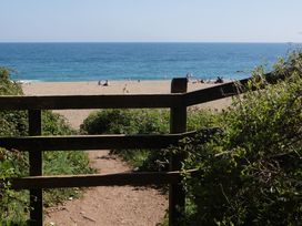 A view of the beach through a wooden gate at Coach House Cottage, Strete, near Dartmouth