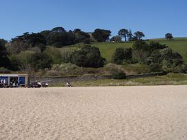 A beach with a café and people at Coach House Cottage in Strete, near Dartmouth