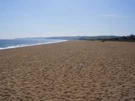 A beach with sand and ocean at Coach House Cottage, Strete, near Dartmouth