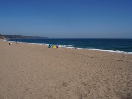 A beach with people and tents at Coach House Cottage in Strete, near Dartmouth