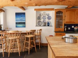 A kitchen with bar stools and ceramic plates at East Bickleigh Halwell
