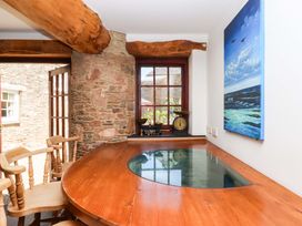 A dining room with a wooden table and window at East Bickleigh in Halwell