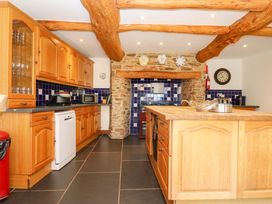 A kitchen with wooden cabinets and a kitchen island at East Bickleigh in Halwell