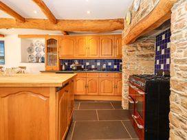 A kitchen with wooden cabinets and an oven at East Bickleigh in Halwell