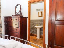 A bedroom with a dresser and a doorway to a bathroom at East Bickleigh in Halwell