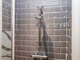 A shower with tiled wall and showerhead at East Bickleigh Halwell
