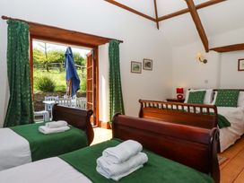 A bedroom with two beds and a view of outdoor seating at East Bickleigh Halwell