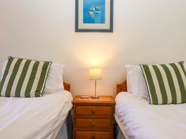 A bedroom with two beds and a lamp on a nightstand at East Bickleigh Halwell