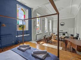 A living room with a bed and table at The Music Room in Aveton Gifford