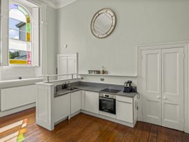 A kitchen with cabinets and appliances at The Music Room in Aveton Gifford