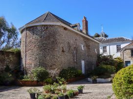 An outdoor area with stone walls and potted plants at The Music Room near Aveton Gifford