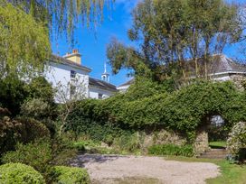 A garden with trees and a gravel area at The Music Room near Aveton Gifford