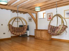 A living room with hanging chairs and a television at The Roundhouse in Halwell