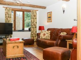 A living room with a sofa and television at The Hay Barn in Halwell