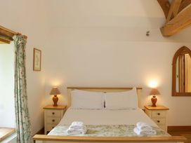 A bedroom with a bed and bedside tables at The Hay Barn Halwell