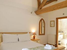 A bedroom with a bed and a bathroom access at The Hay Barn in Halwell