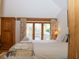 A bedroom with a bed and wardrobe at The Hay Barn in Halwell