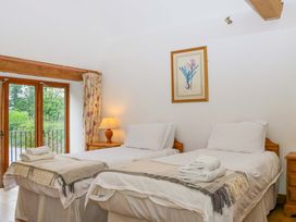 A bedroom with two beds and a window at The Hay Barn in Halwell